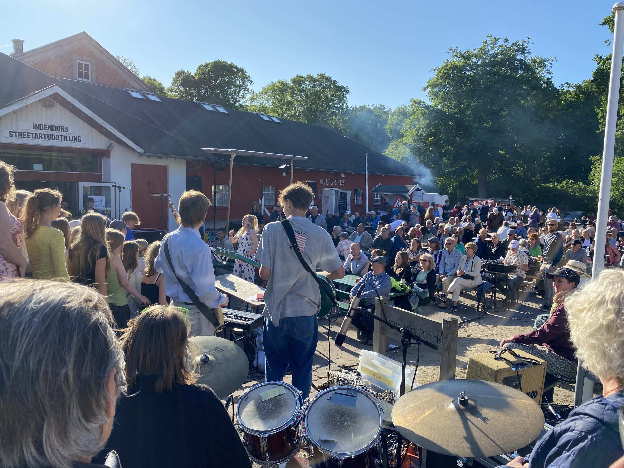 Unge mennesker i et band spiller til Blå Nat foran Rejsestalden.